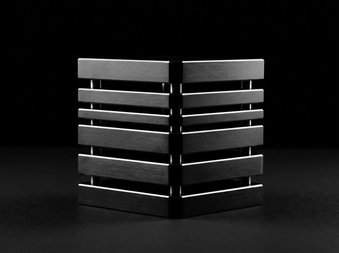 Six precision milled metal plates stacked with light passing between the layers